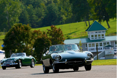 A 1965 JAGUAR XK-E AND AN EARLY 1960S AUSTIN-HEALEY 3000 LEAVE THE LIME ROCK ENTRANCE FOR THE THURSDAY PARADE. PHOTOS BY GREG CLARK AND CASEY KEIL, COURTESY OF LIME ROCK PARK.